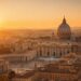 Vista aérea del Vaticano al atardecer con la cúpula de San Pedro y la Plaza de San Pedro en Roma