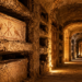 Recreación ilustrativa del interior de unas catacumbas romanas, con galerías subterráneas y antiguos nichos funerarios